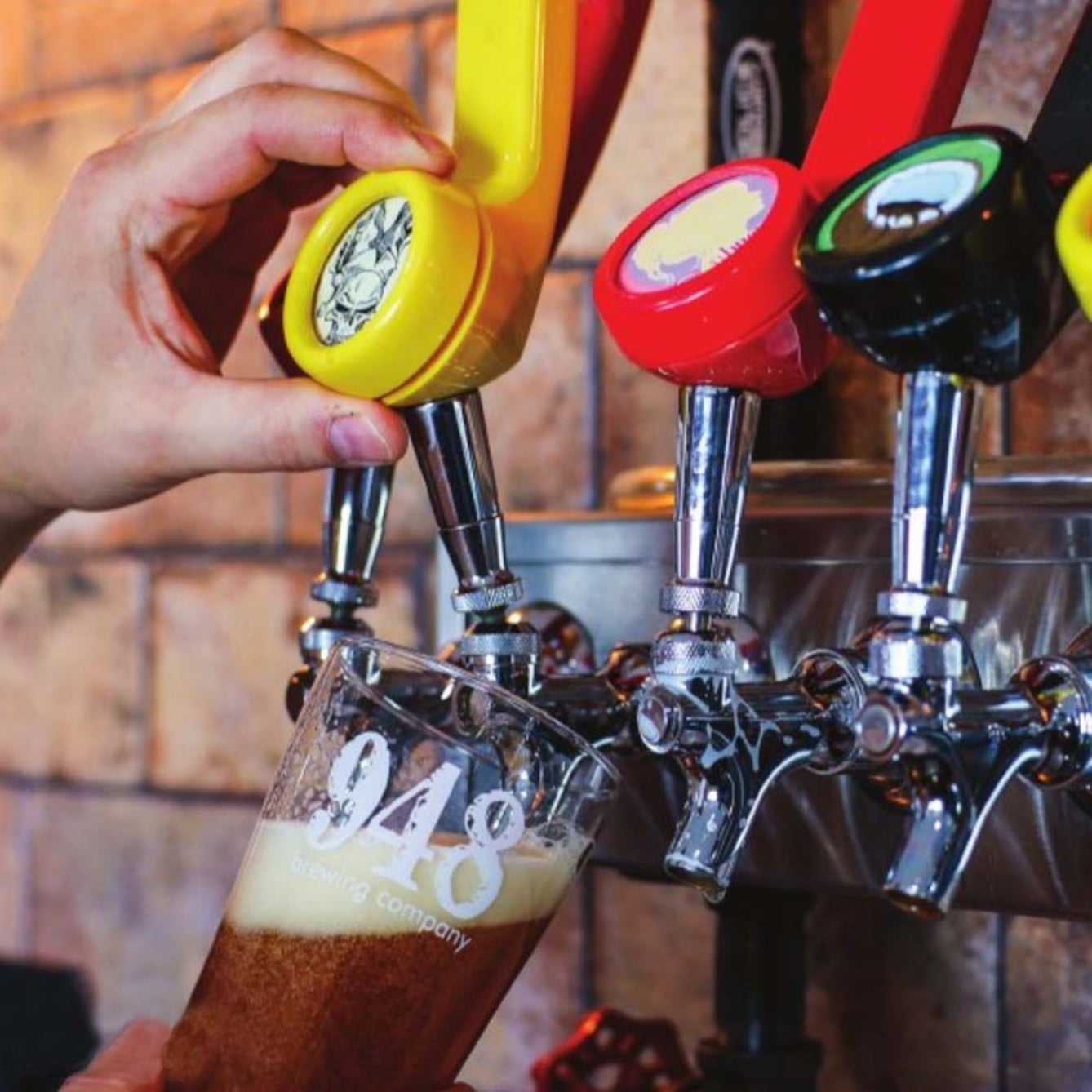 a person is pouring beer from a 948 telephone beer tap