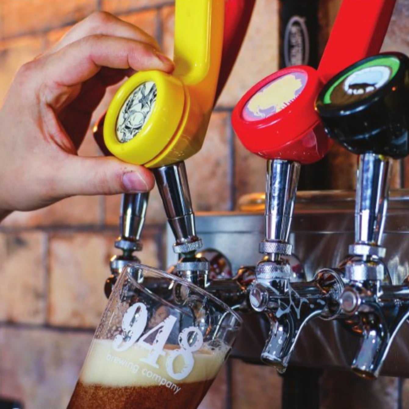 a person is pouring beer from a 948 telephone beer tap