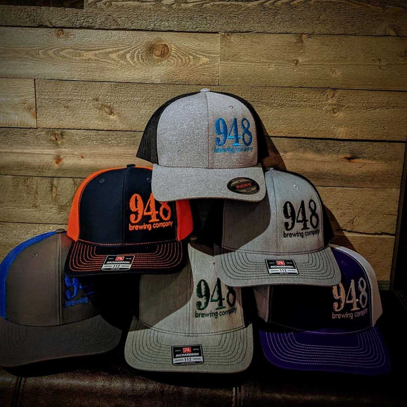 a pile of 948 Brewing Company hats